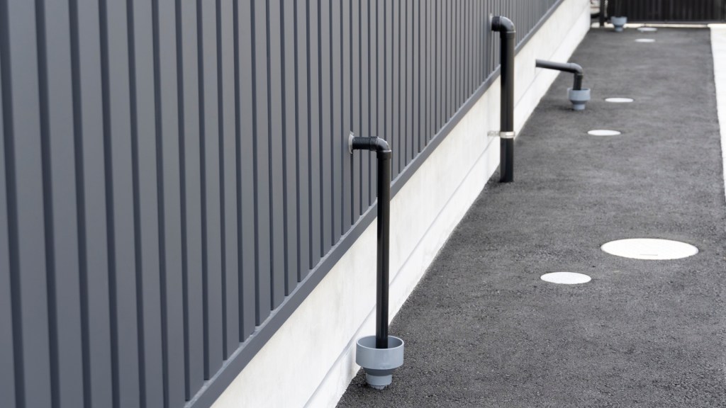 Commercial drainage system installation with oversized gutters and downspouts protecting building exterior