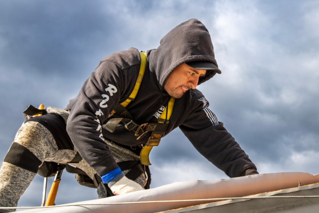 Lemus Construction team installing asphalt shingle roof on a commercial shopping center