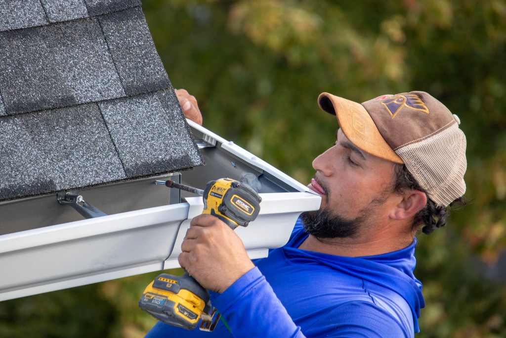 Team installing gutters along building edge at The Villas at Packer Park, Philadelphia, PA