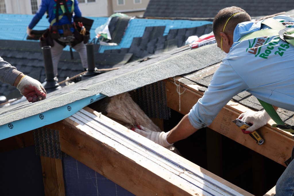 Team member inspecting attic insulation after roof replacement at The Villas at Packer Park